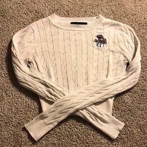 White cropped knit sweater with engraved mushrooms on shoulder.